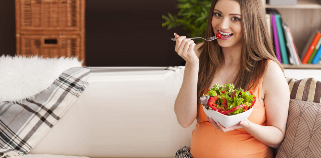 Pregnant woman eating healthy salad